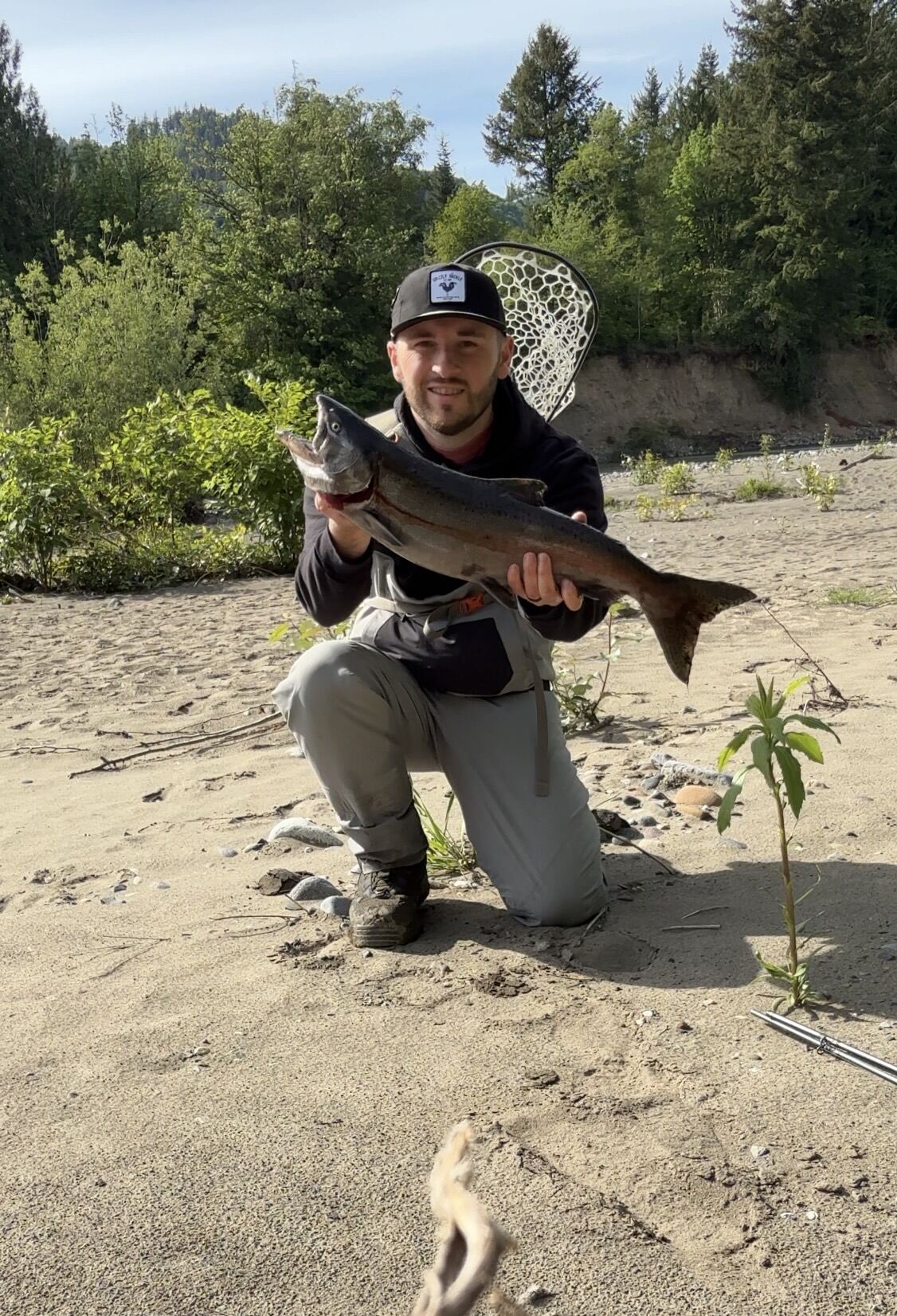 Dr. Dakota with a freshly caught salmon by the river