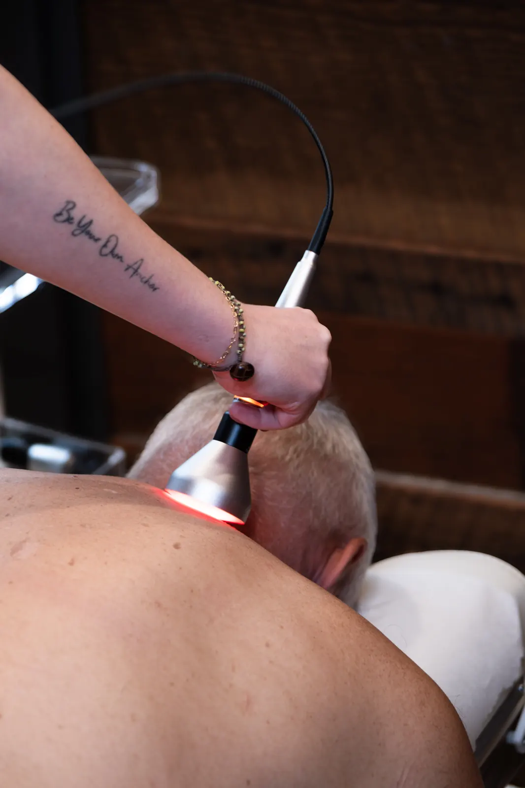 Cold laser therapy device delivering red-light treatment at Envision Chiropractic Bellingham
